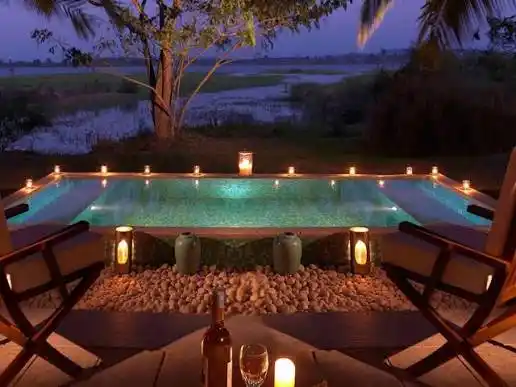 Romantic candlelit private pool setup surrounded by nature in Coorg, Karnataka.